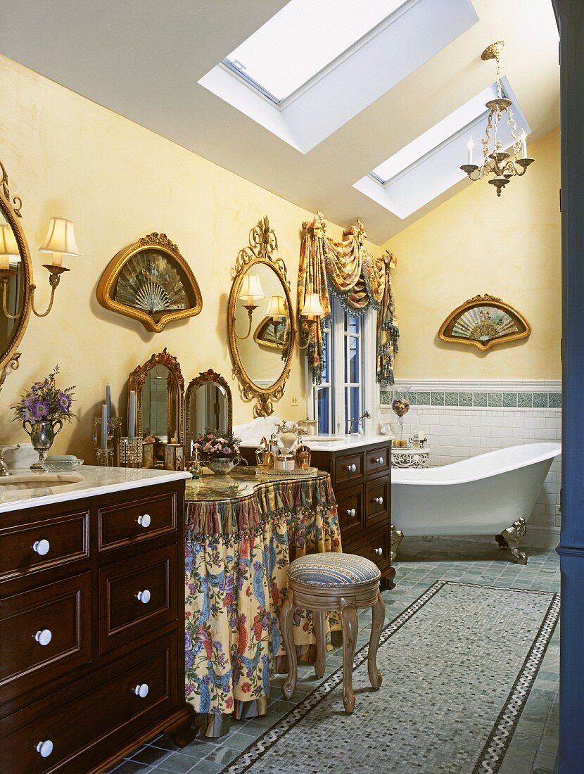 Prunkvolles Badezimmer unter der Dachschräge mit einer freistehenden Badewanne und goldgerahmten Bildern in Fächerform an den Wänden