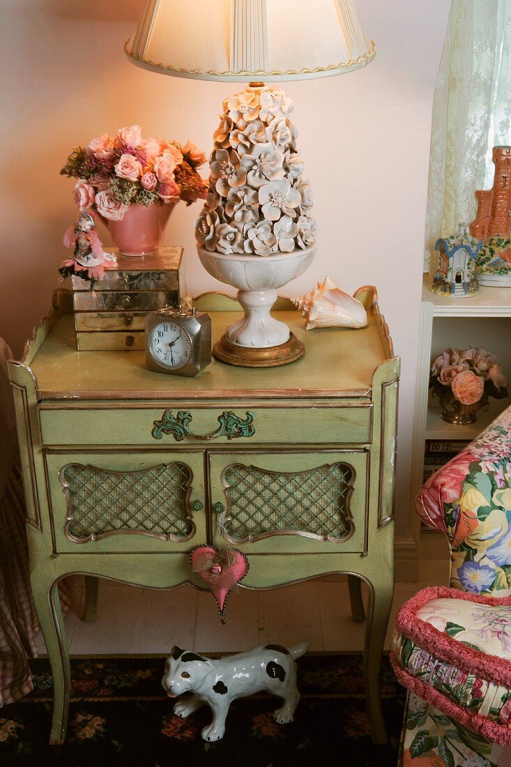 Antique bedside table with ceramic bowl of flowers as lamp base