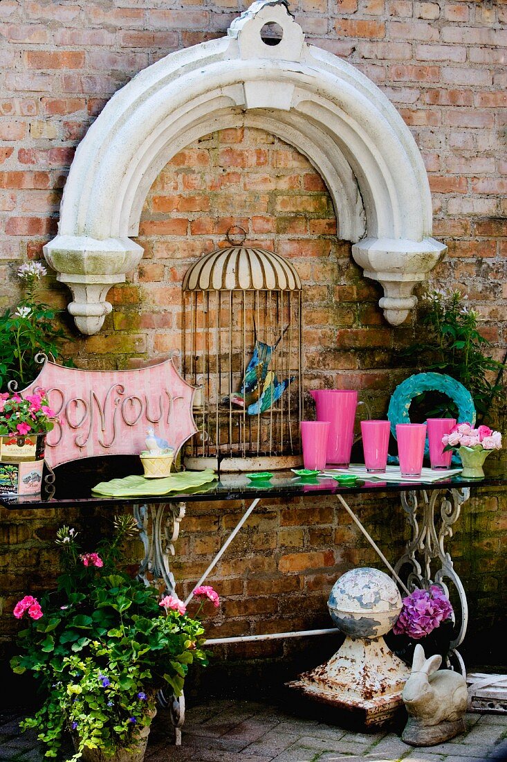 Brick wall decorated with stone arch and birdcage