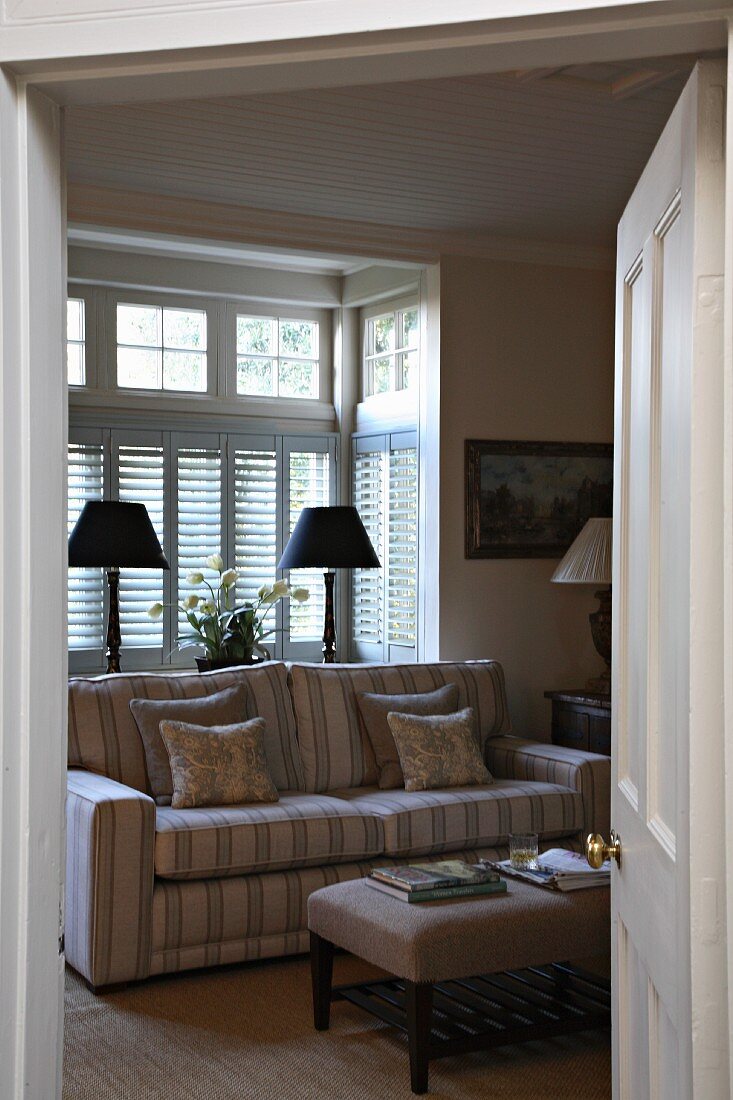 Blick durch Tür in Wohnraum auf Sofa in ländlichem Stil