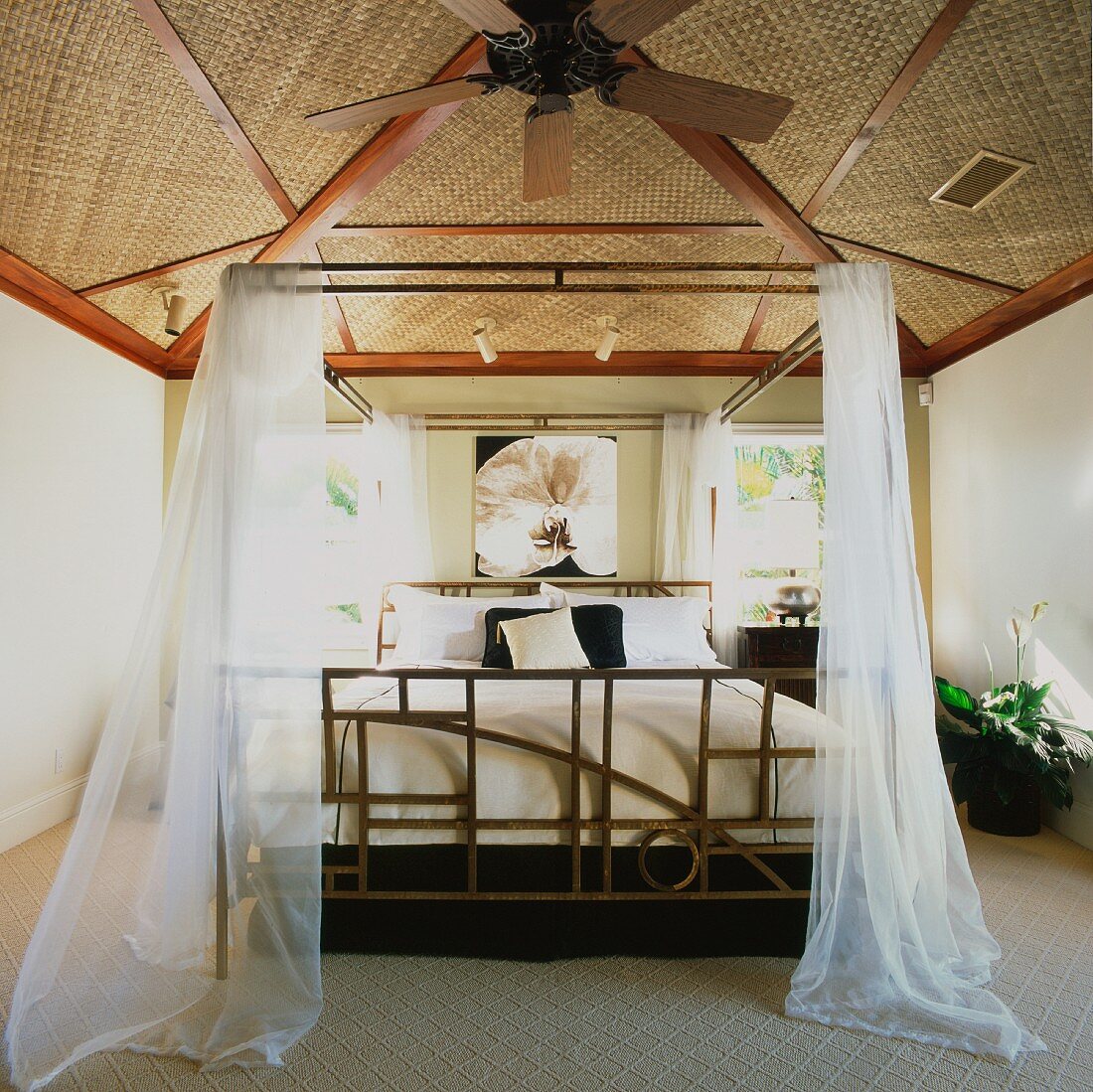 Doppelbett mit Moskitonetz und ein Ventilator in einem Hawaii-Schlafzimmer