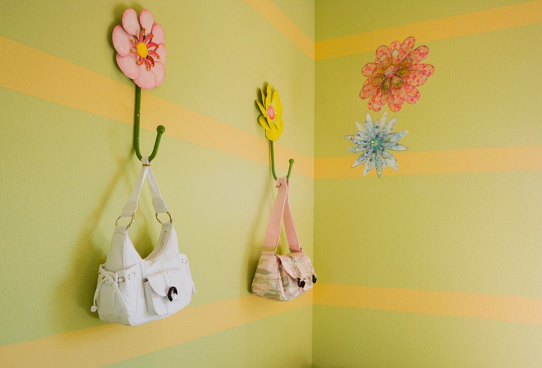 Streifenmuster an Wand mit Handtaschen an Wandhaken aufgehängt