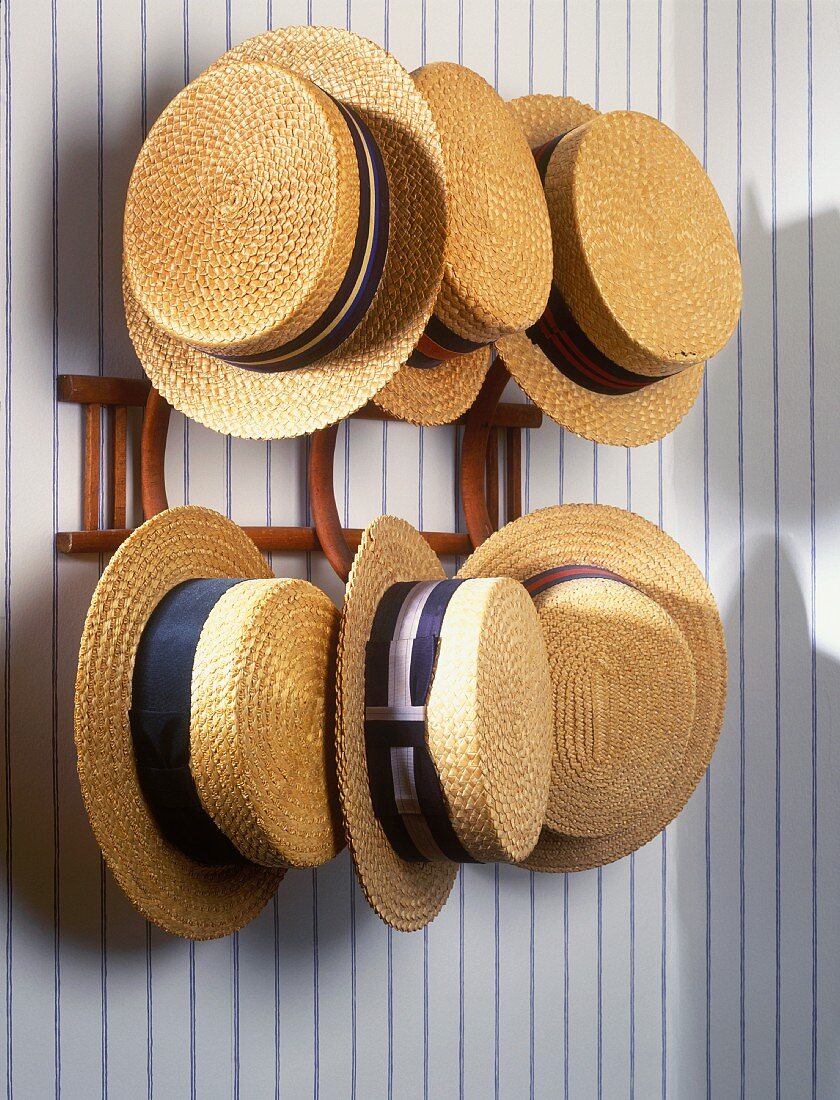 Twenties-style straw hats hanging on wooden hat pegs