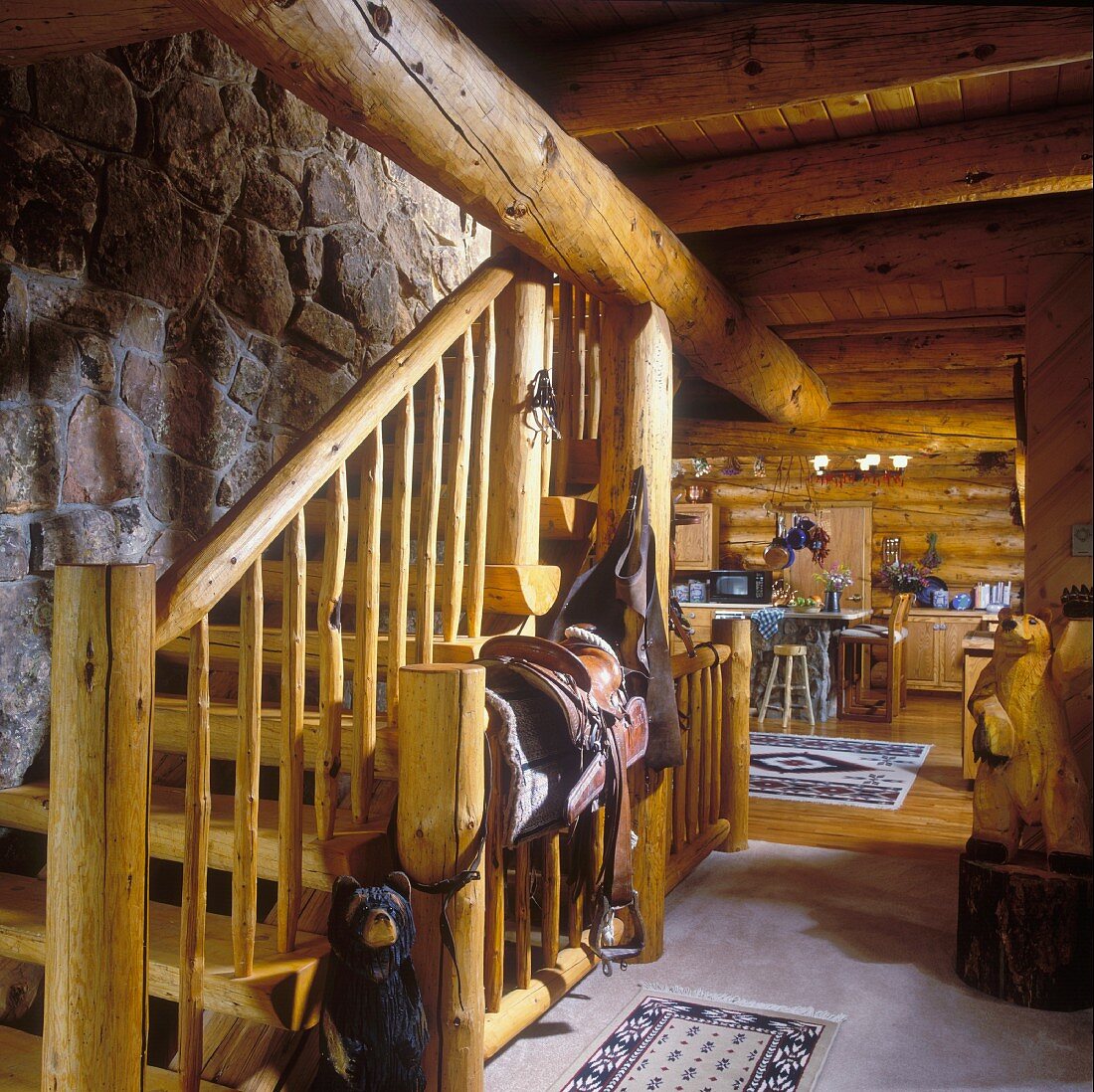 Rustikales Blockhaus mit Natursteinwand, Treppenaufgang und Blick in den Essbereich