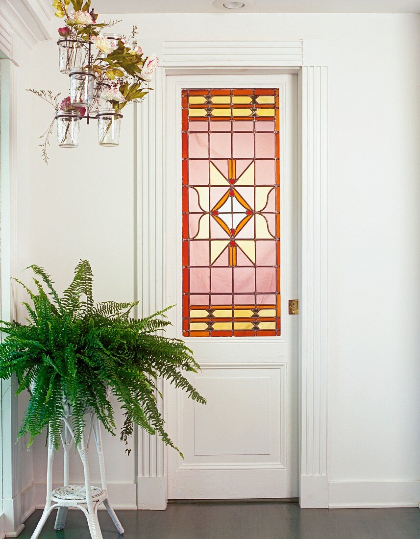 weiße Tür mit kunstvollem Bleiglasfenster