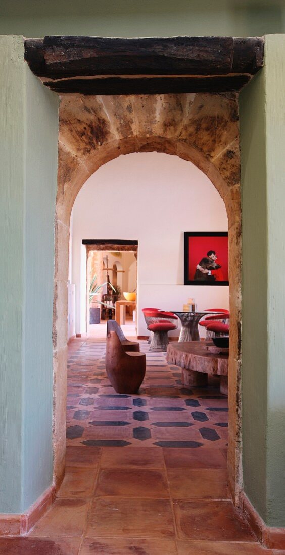 Vorraum mit Rundbogen und Blick in Wohnraum eines rustikalen Landhauses in mediterranem Stil