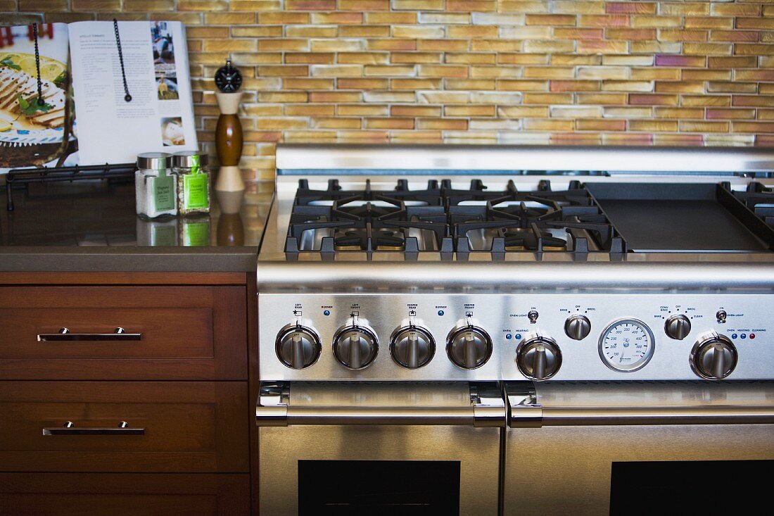 Contemporary stainless steel stove oven with tile backsplash