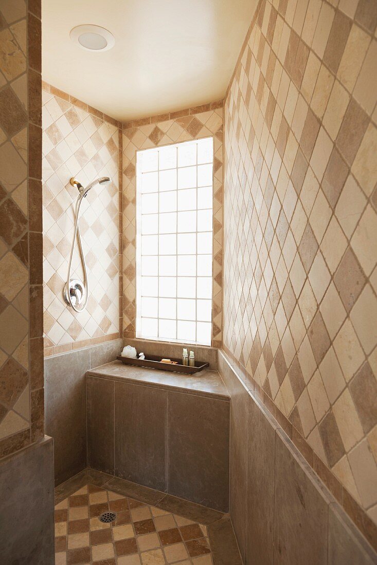 Bad mit diagonal verlegten Wand- und Bodenfliesen in verschiedenen Brauntönen