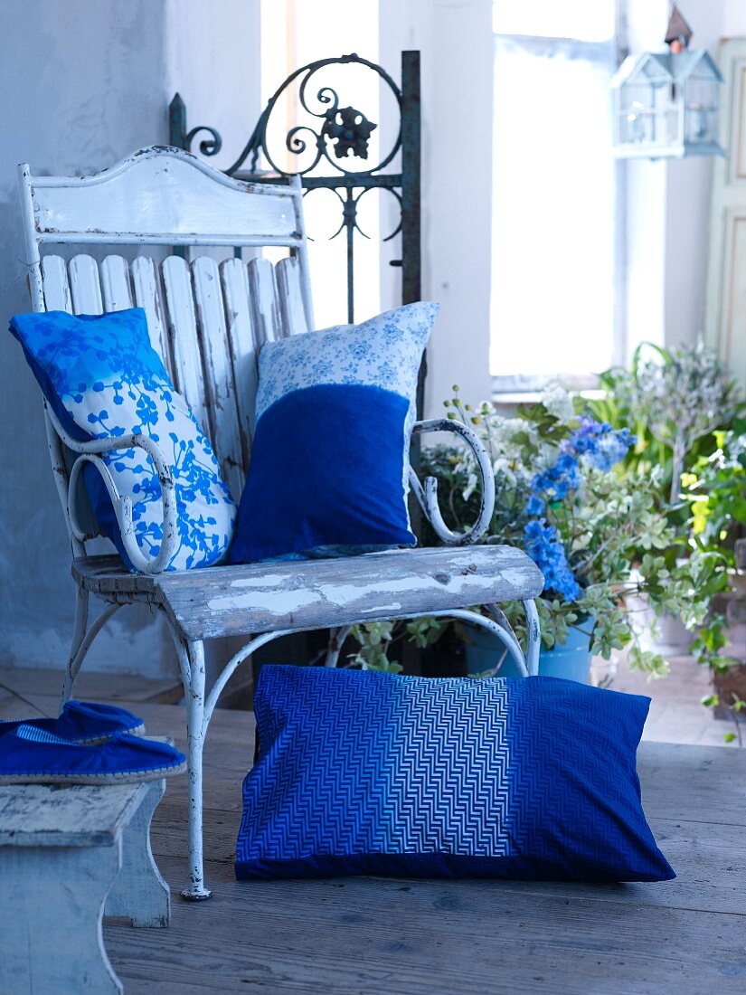 Blue and white decorative pillows on a wooden chair