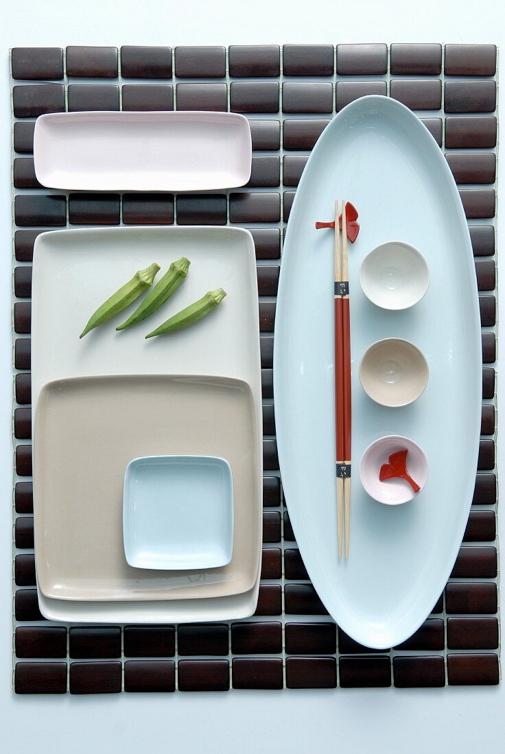 Tischset mit japanischem Gedeck aus verschiedenen Schalen geometrisch angeordnet.