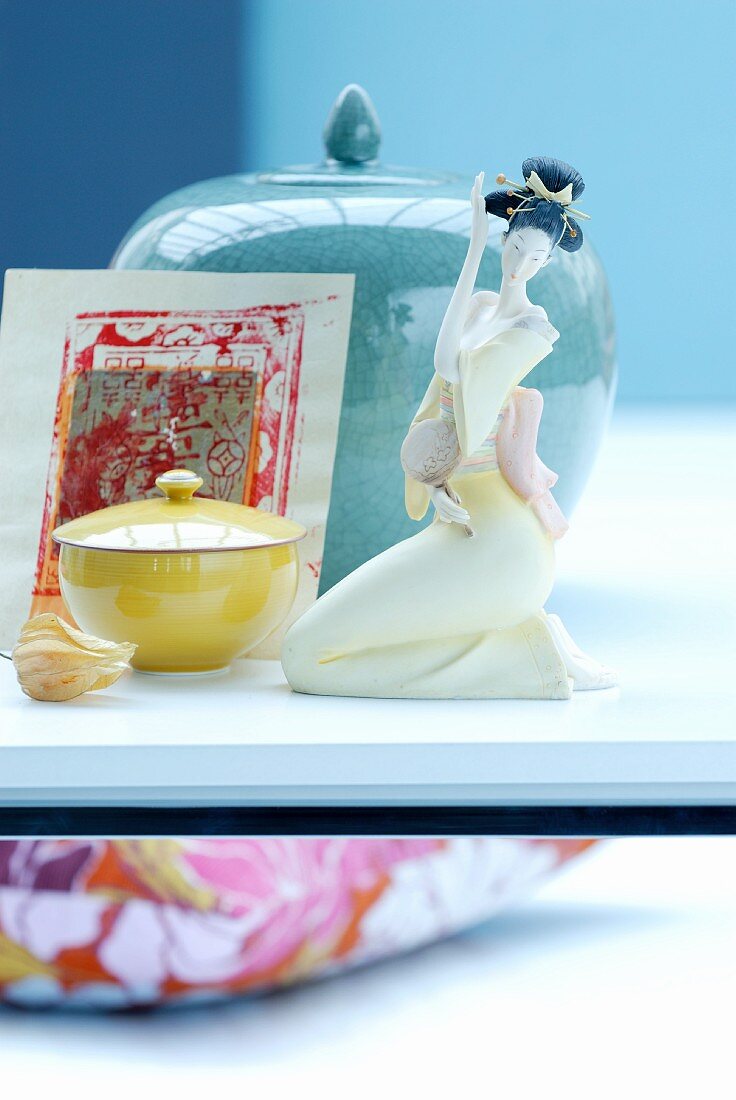 Arrangement mit verschiedenen Porzellandosen und einer sitzenden japanischen Frauenporzellanfigur