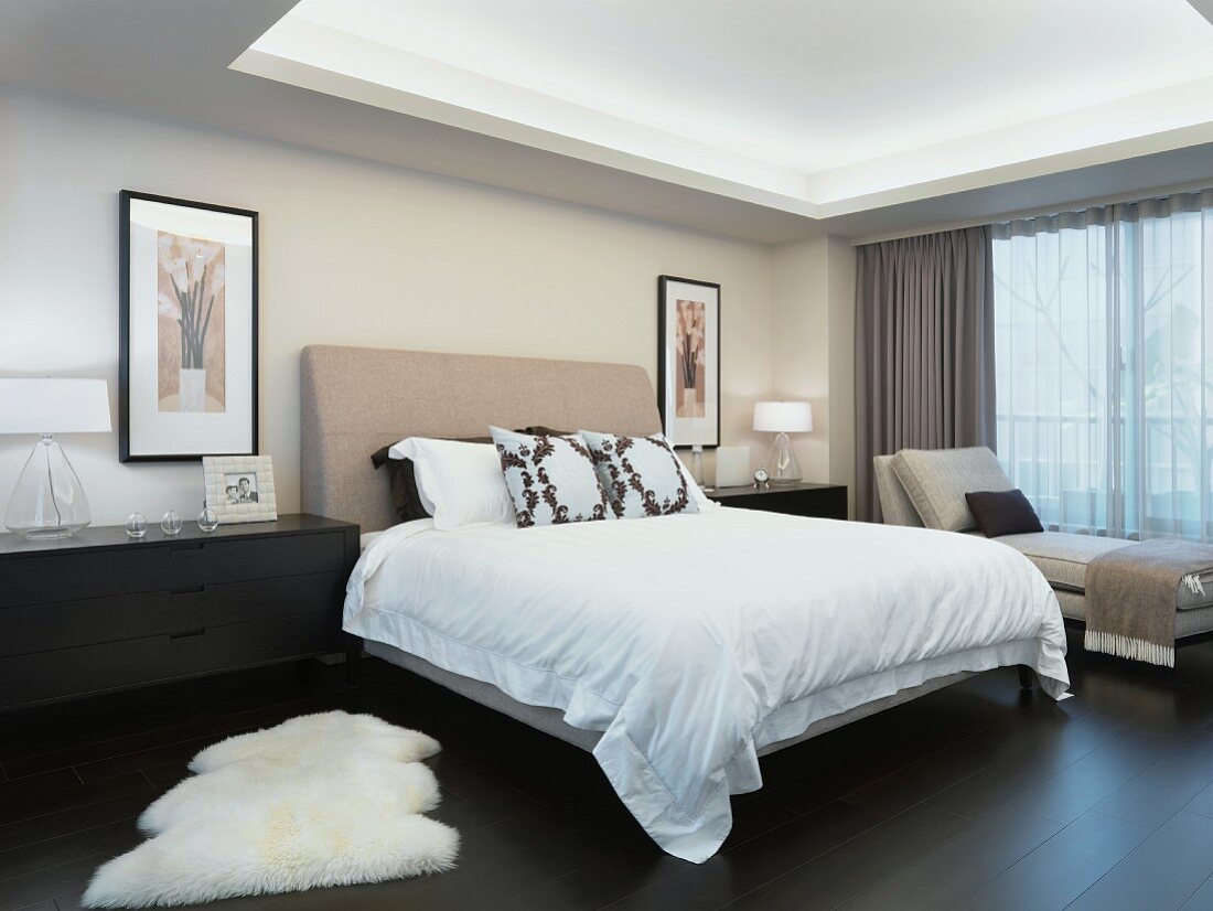 Doppelbett mit gepolstertem Kopfteil unter indirekter Deckenbeleuchtung in modernem Schlafzimmer