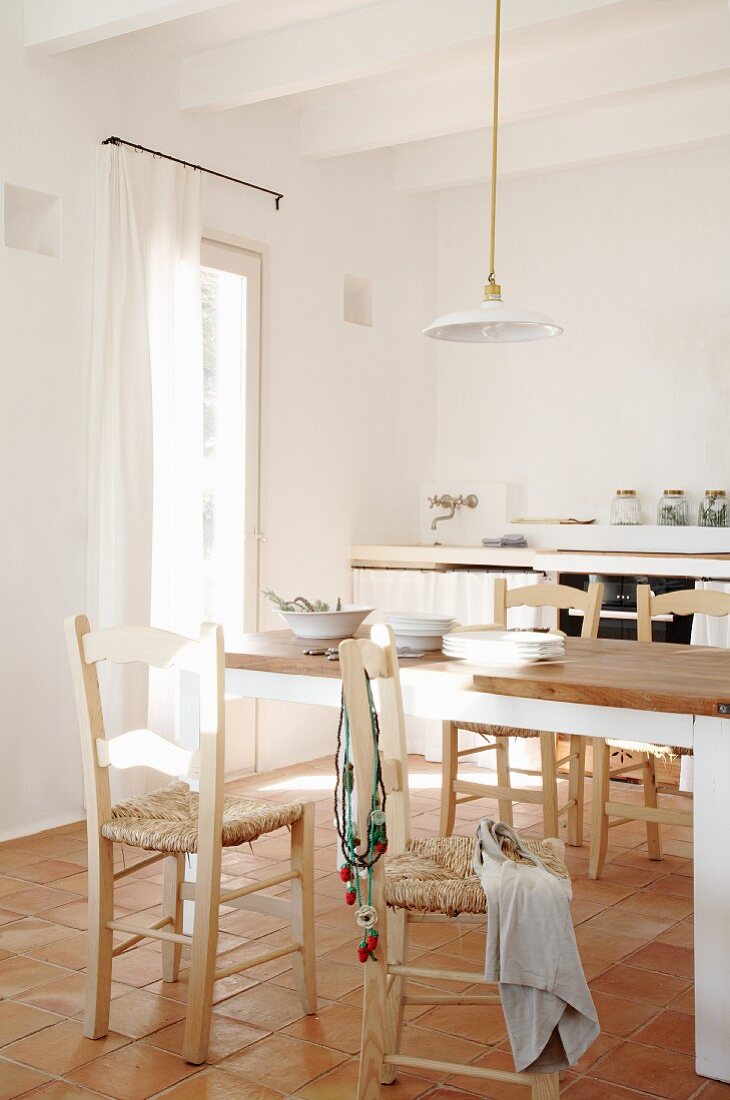 Grosse Wohnküche in mediterranem Stil - Esstisch und Stühle mit Binsengeflecht