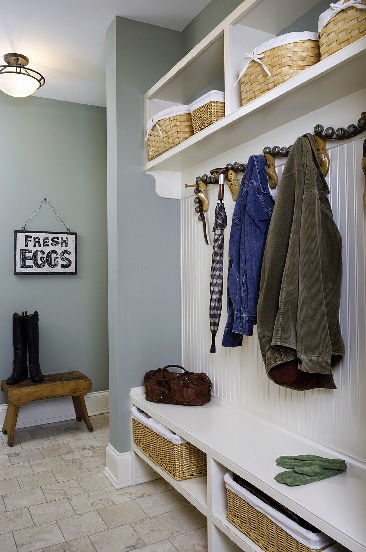 Cloakroom with storage baskets on shelves against grey-painted walls