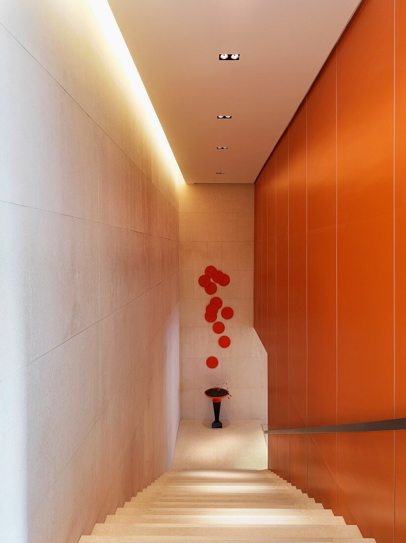 Modernes Treppenhaus mit dekorativen, orangefarbenen Akzenten