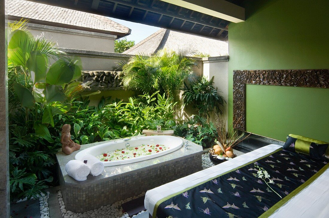 Grüner Raum in einem Spa mit eingelassener Badewanne und Massagebank