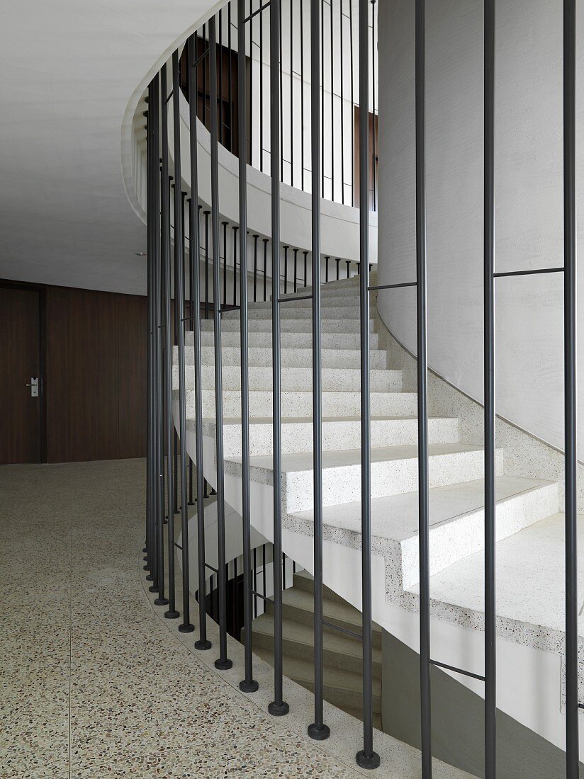 Contemporary winding staircase surrounded by bars