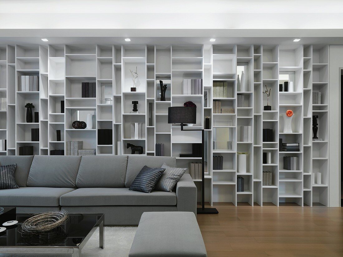 Verschachtelte Regalwand in modernem Wohnzimmer mit grauen Polstermöbeln