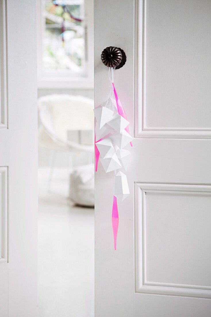 White, folded paper tags and pink stripes on the doorknob