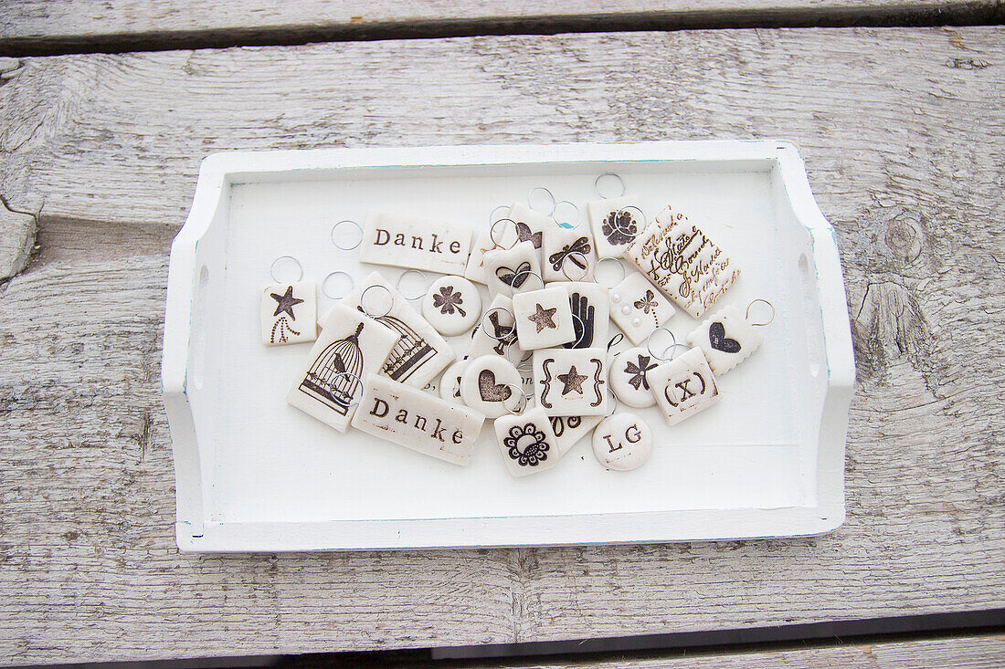 Hand-made polymer clay gift tags on white wooden tray