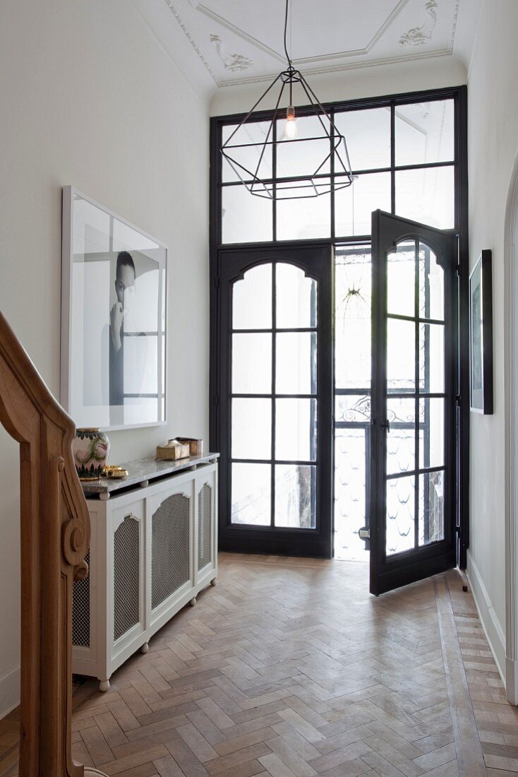 Eleganter Eingangsbereich einer Villa, Flügeltür aus Holz und Glas, moderne Pendelleuchte an Stuckdecke