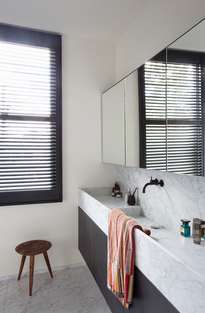 Waschtischzeile mit trogartigen Becken aus Marmor, oberhalb Spiegelschrank an Wand