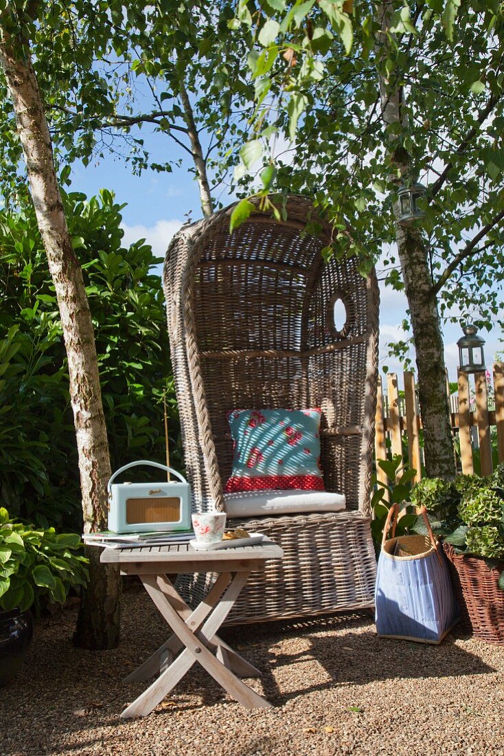 Lauschige Gartenecke mit gemütlichem Strandkorb und Gartentisch unter Birken