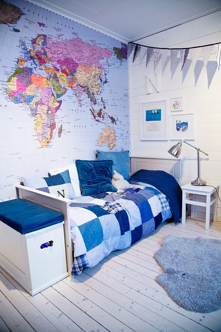 Kinderzimmer in Blautönen mit Weltkarte und Patchworkdecke