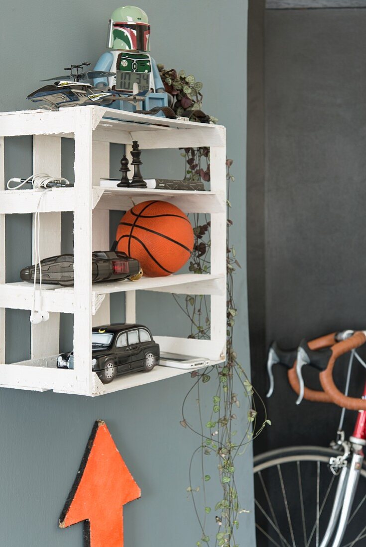 A homemade white wall shelf made from a fruit crate