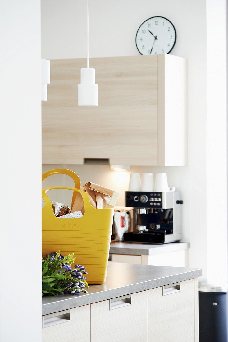Gelbe Einkaufstasche auf Küchentheke, im Hintergrund Kaffeeautomat