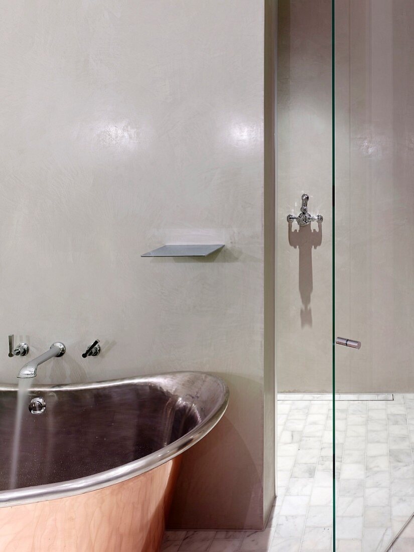 Retro, industrial-style designer bathtub and walk-in shower with polished, glazed walls