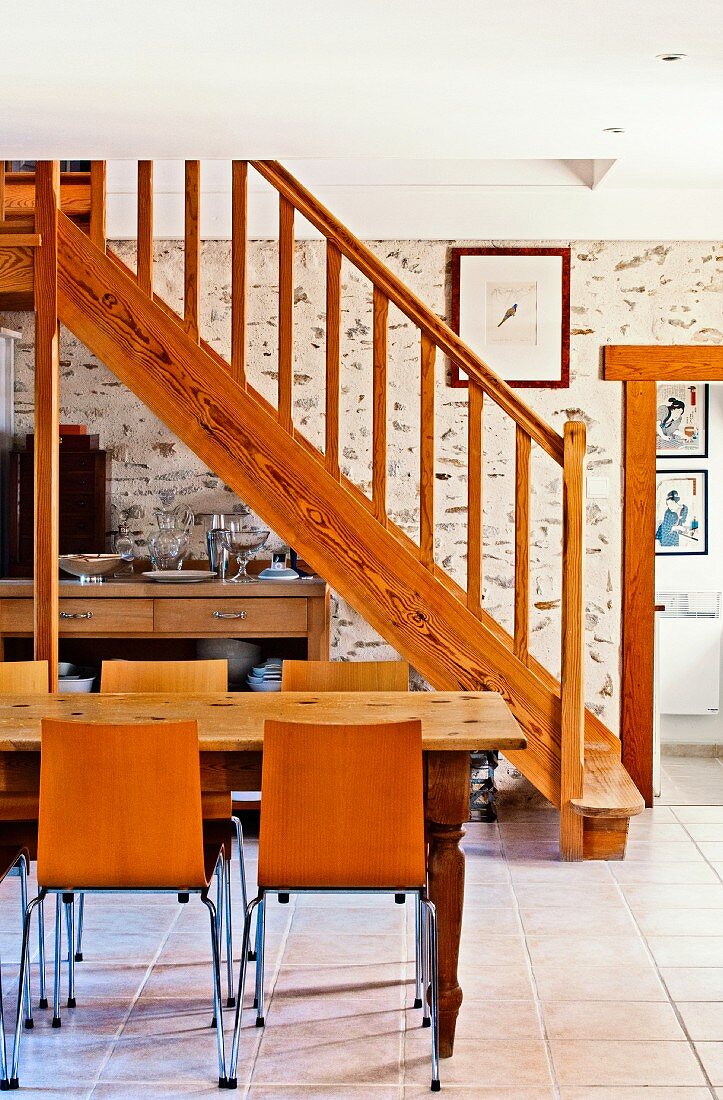 Wooden staircase, stone wall and tiled floor in dining area