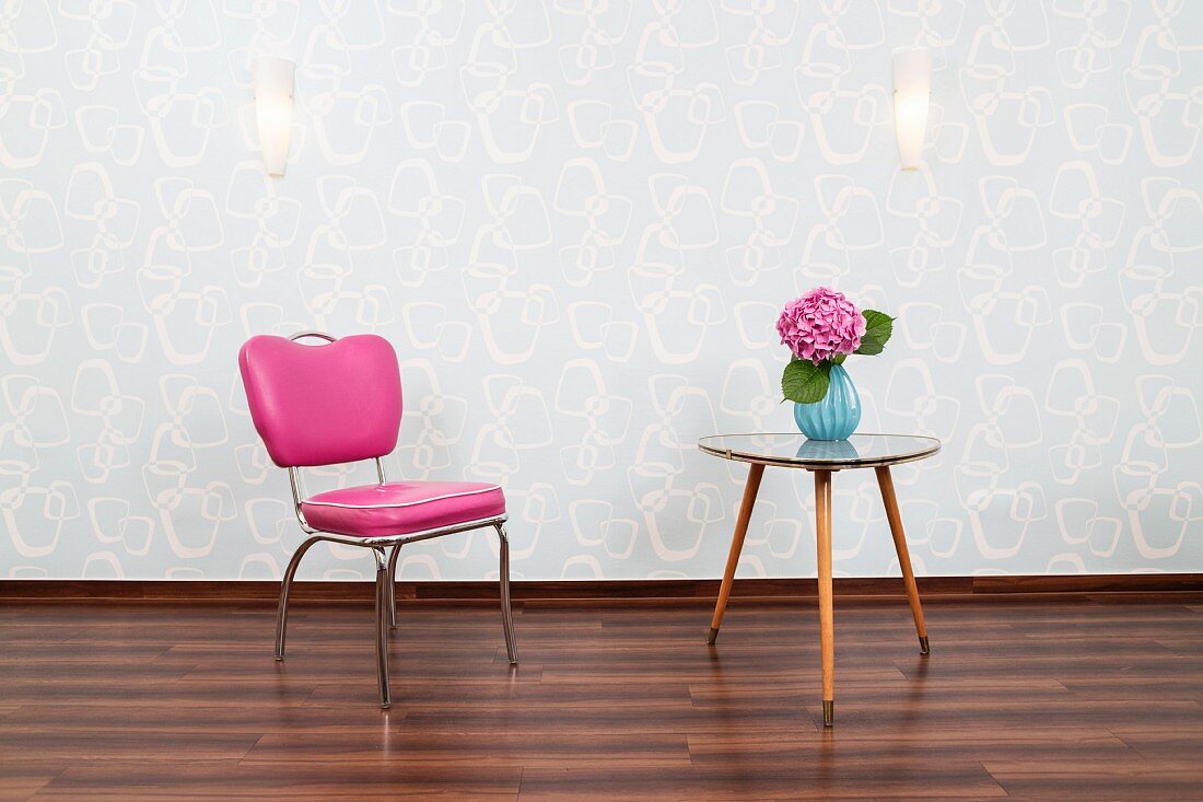 Wartebereich eines Friseursalons mit pinkfarbenem Stuhl & dreieckigem 50er Jahre Tisch
