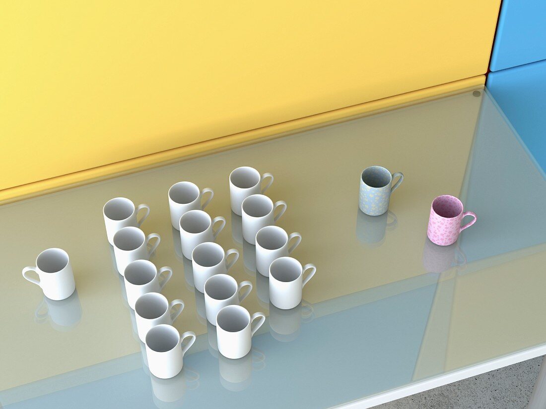 Coffee mugs of different colours on glass table