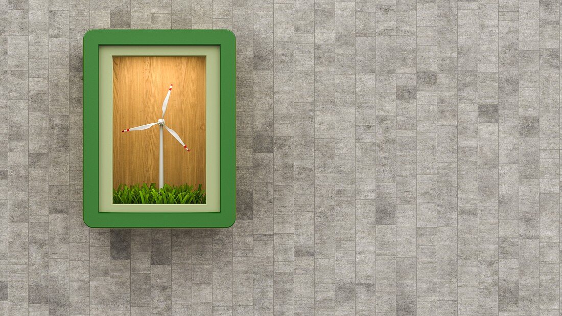 Miniature wind turbine in illuminated display case on grey concrete wall
