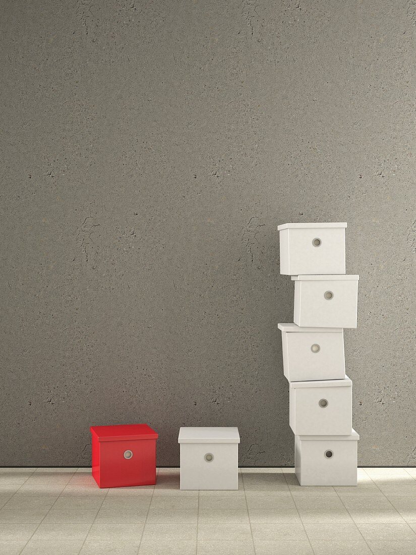 One red and multiple white storage boxes against grey concrete wall