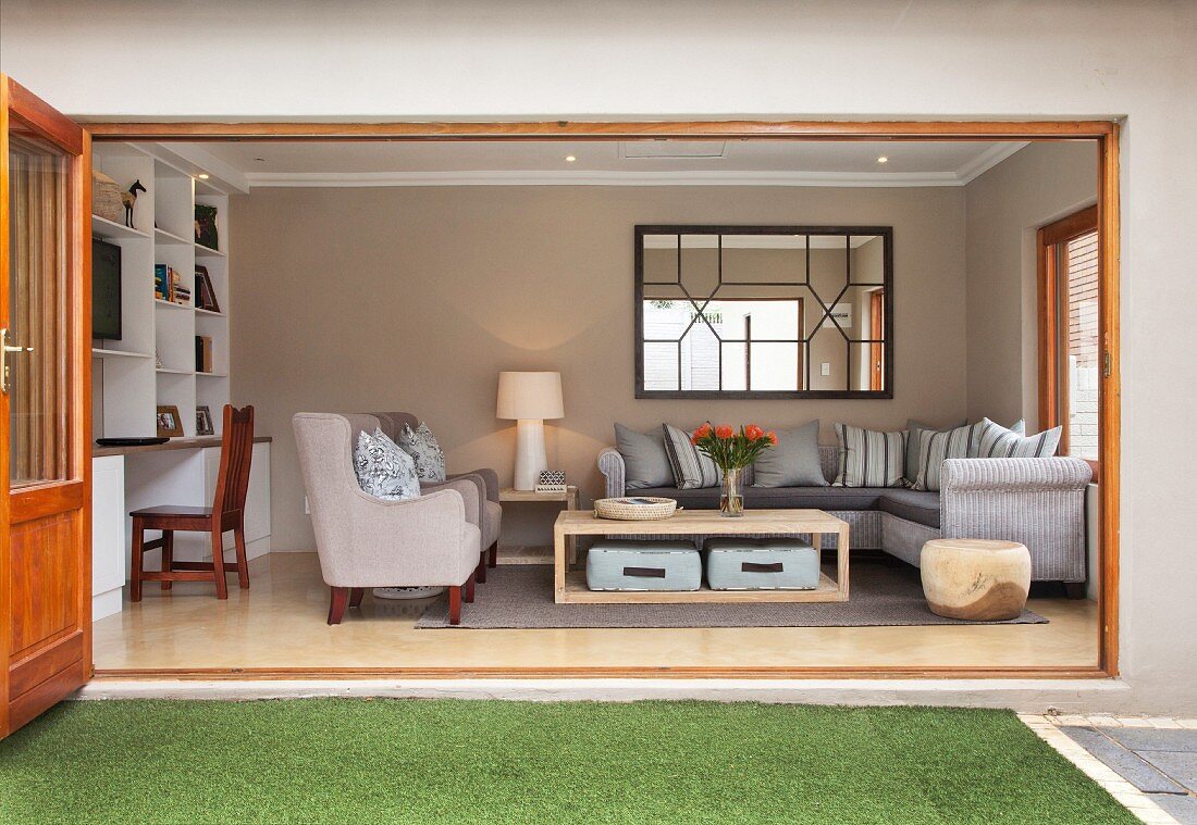 Blick in gemütliches Wohnzimmer mit Polstermöbeln und weißem Einbauregal