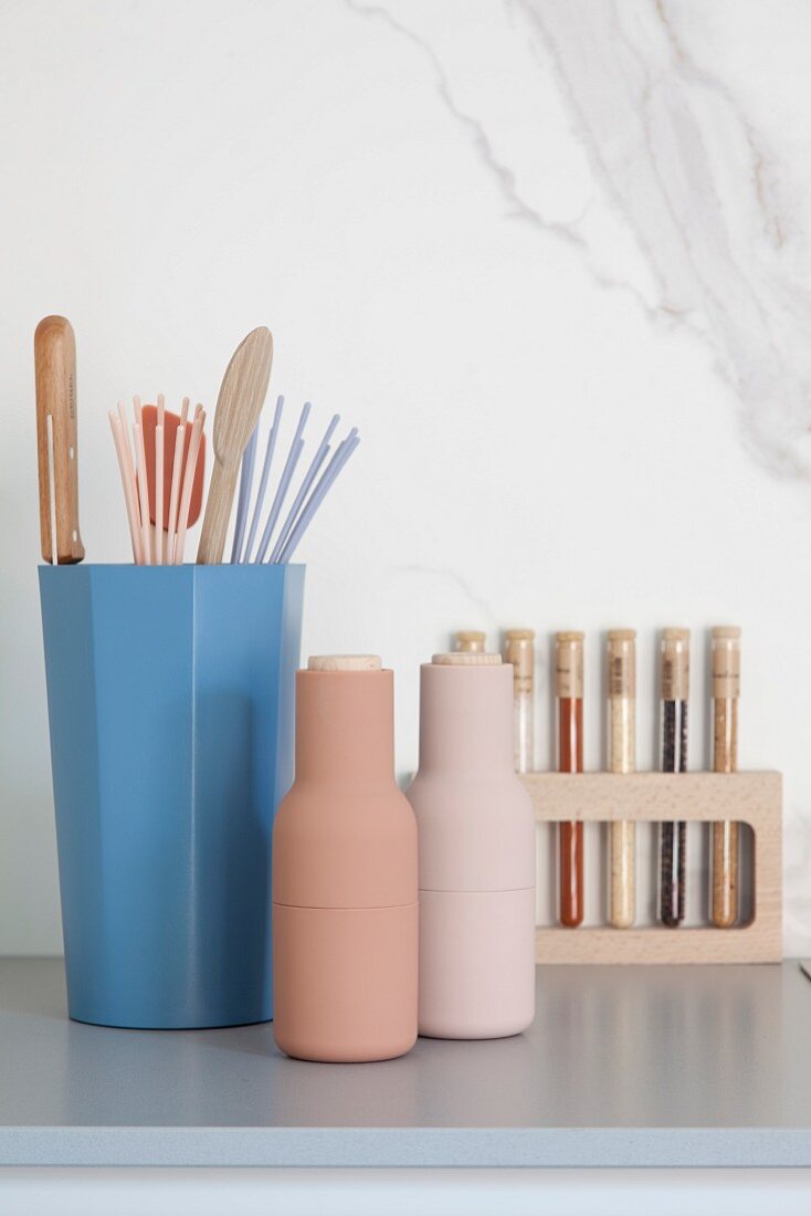 Kitchen accessories in pastel shades against marble wall