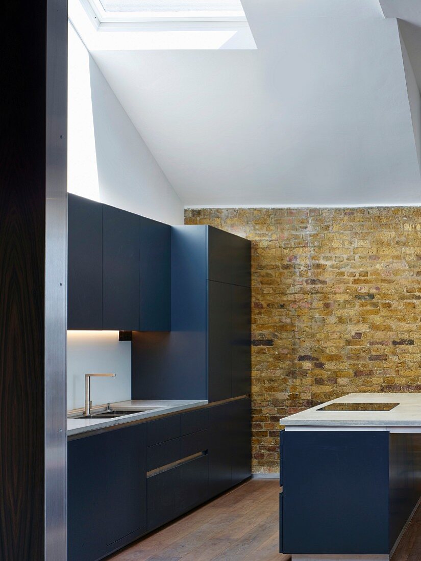 Kitchen with exposed brick wall and skylight