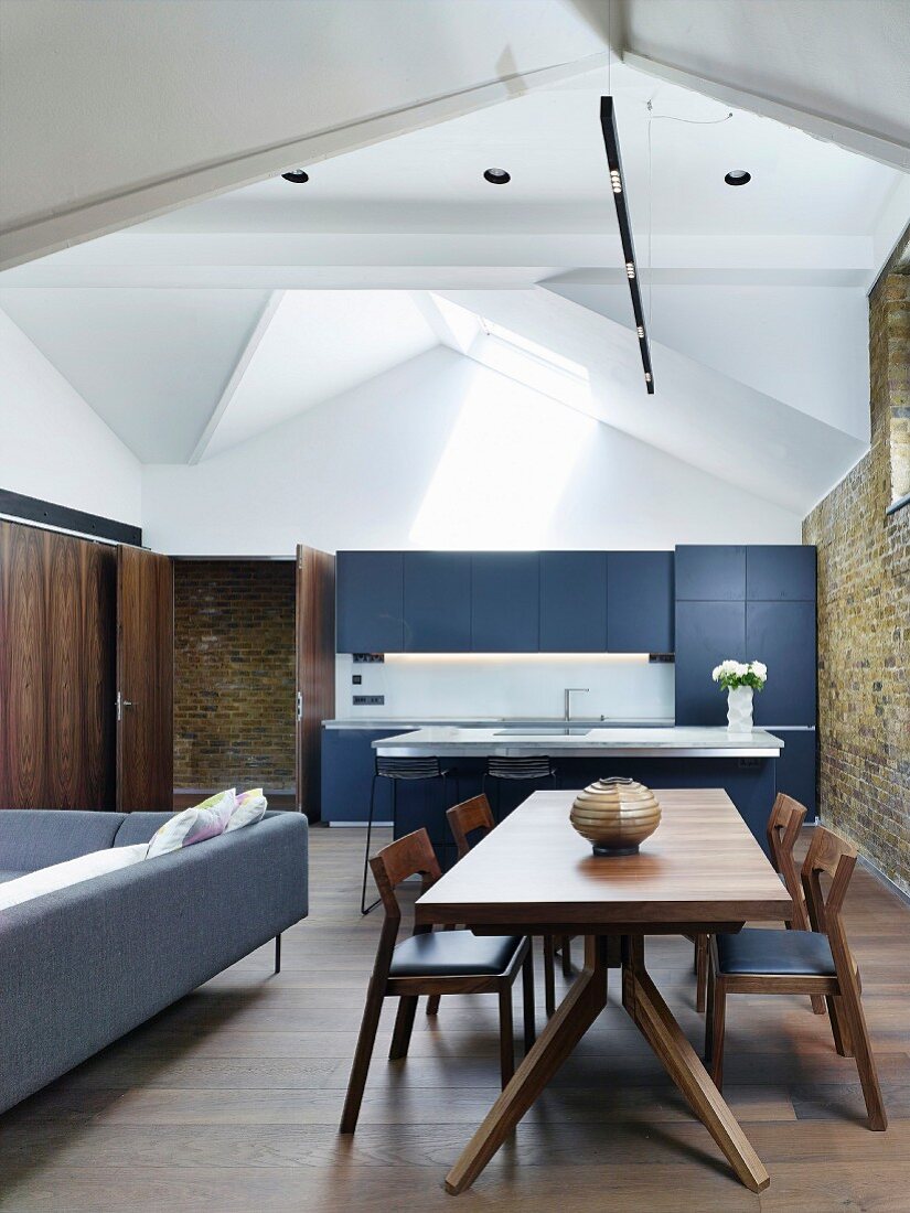 Open-plan attic interior with kitchen and dining table