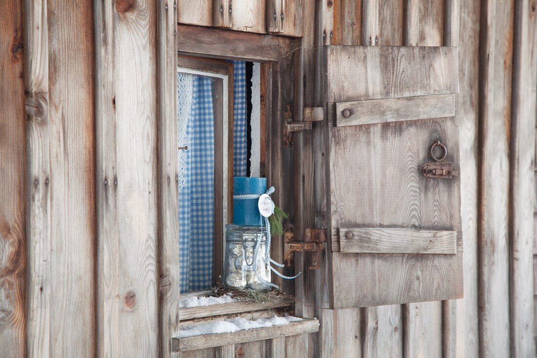 Advent arrangement on windowsill of rustic, weathered hut