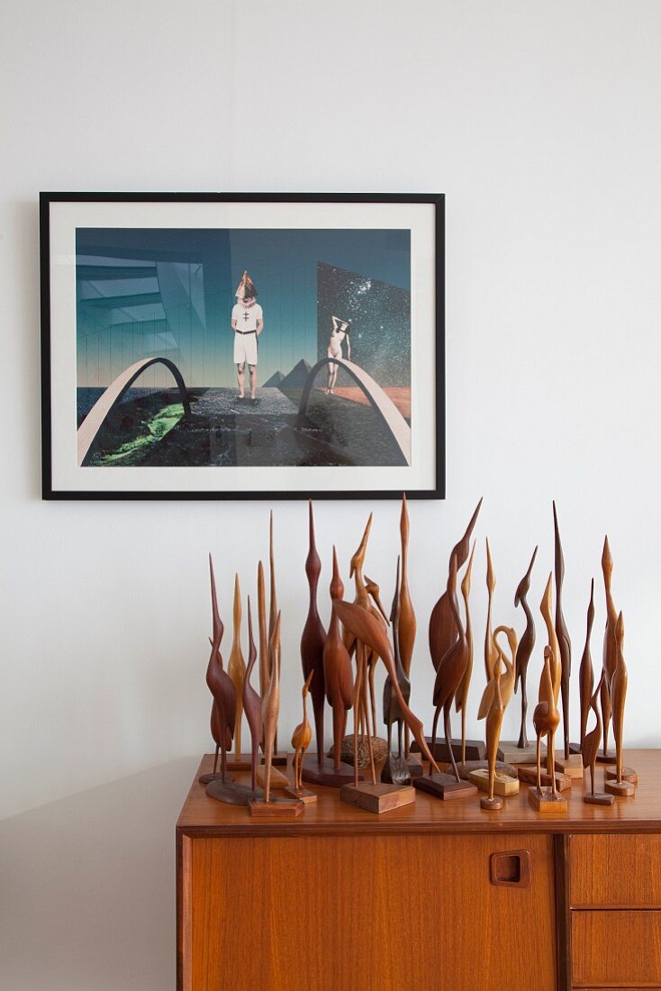 Surrealist artwork above collection of wooden cranes
