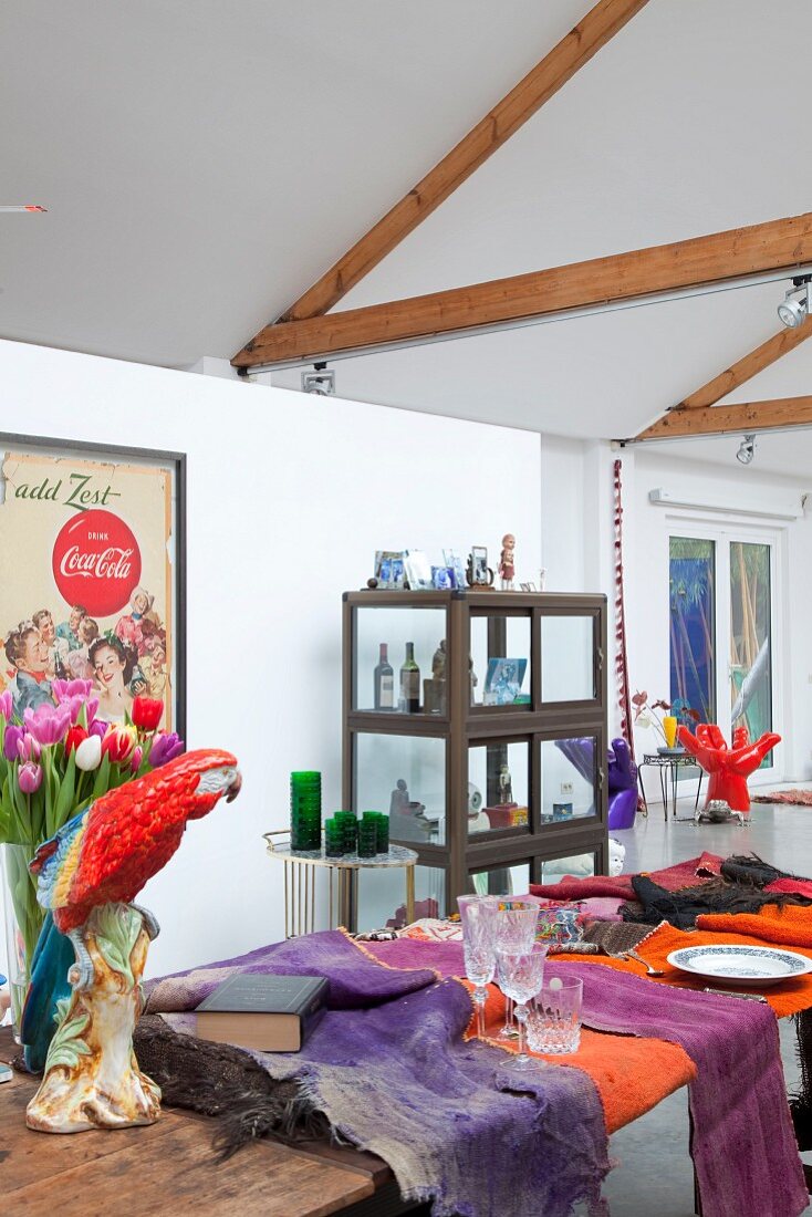 Table set in bright colours in loft apartment with exposed roof structure
