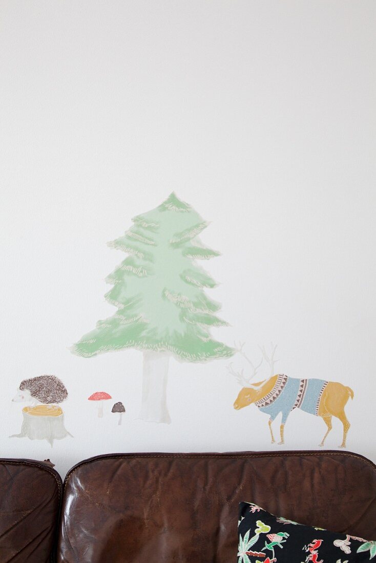 Animal and tree wall-stickers above leather sofa