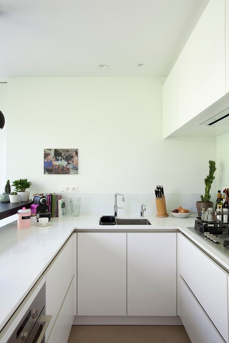 U-förmige Küche mit Oberschränken und weißer Küchenarbeitsplatte