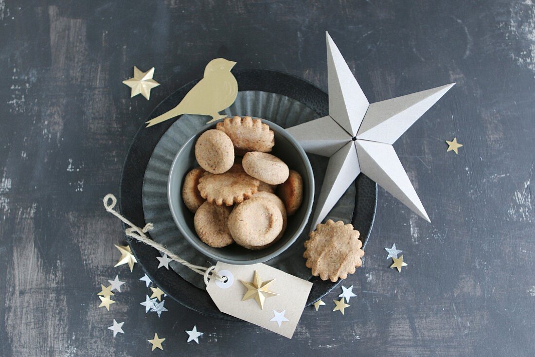 Christmas biscuits on flan tin and stars hand-crafted from paper and gold foil