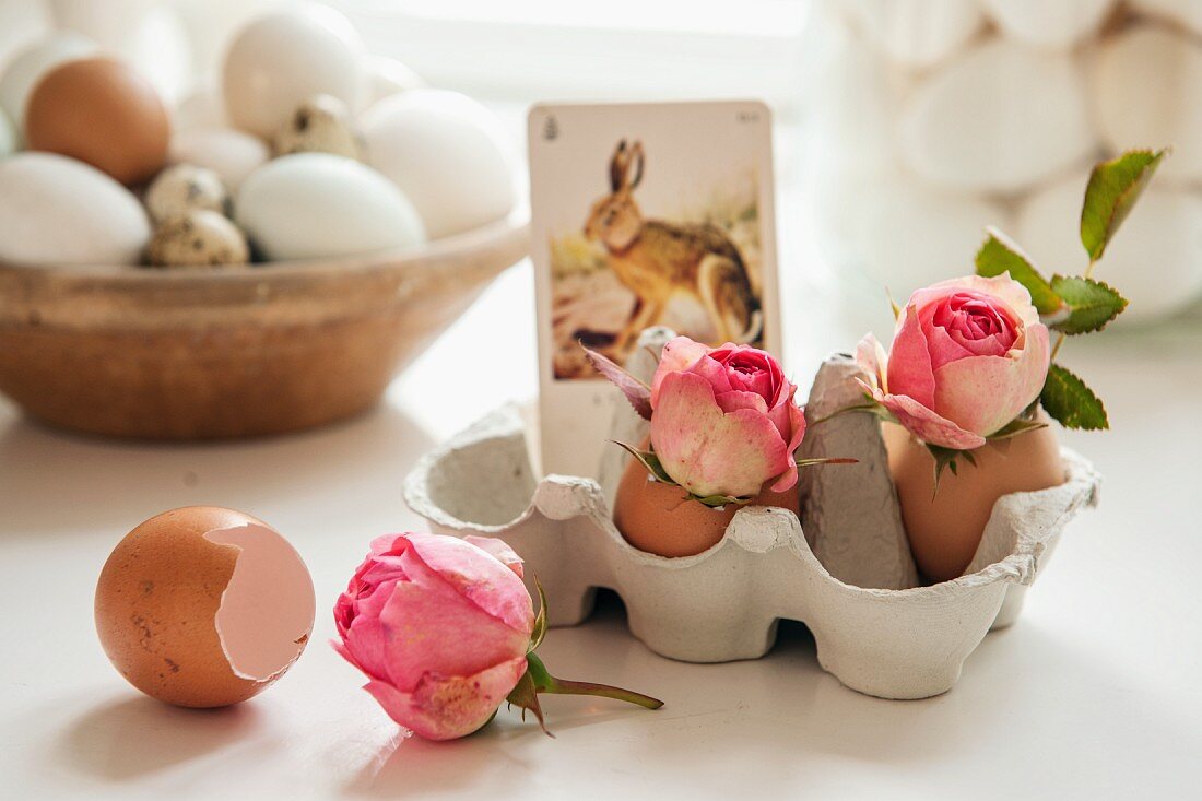 Eierschalen mit Rosenblüten und nostalgische Hasenkarte im Eierkarton
