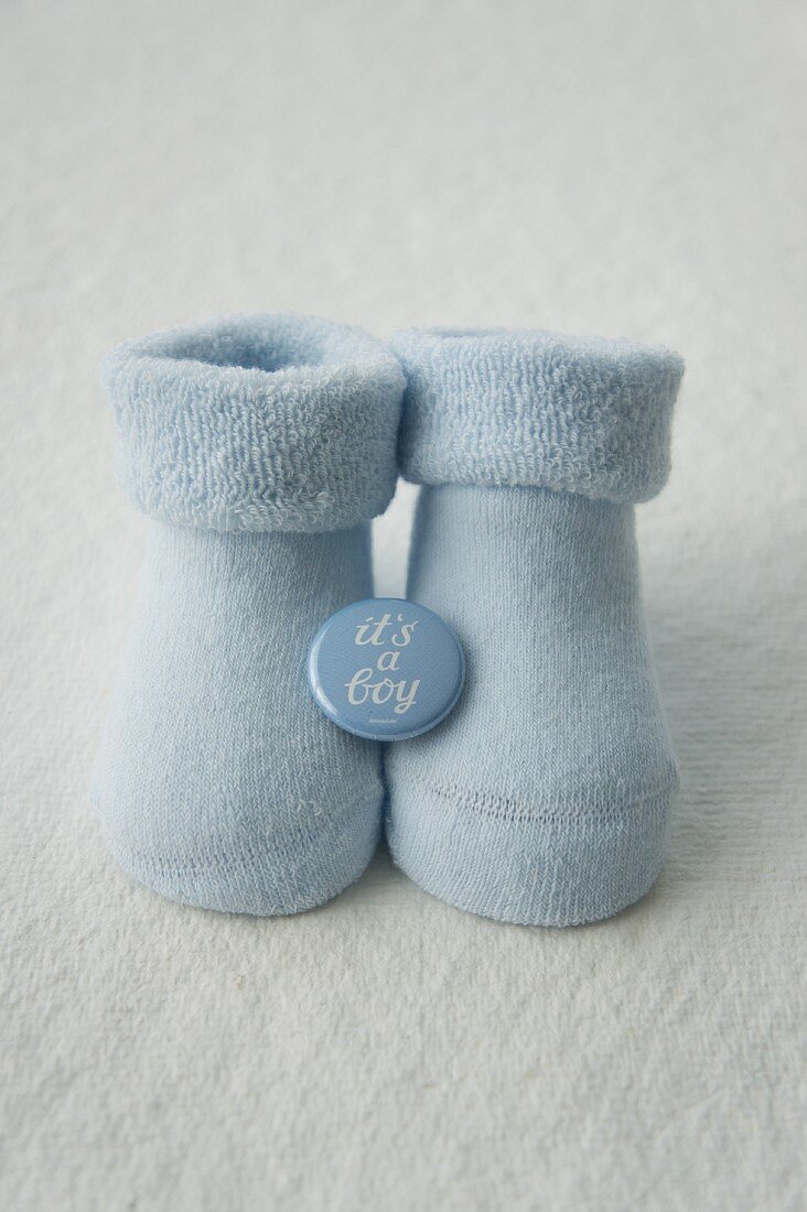 Blue baby socks with a badge