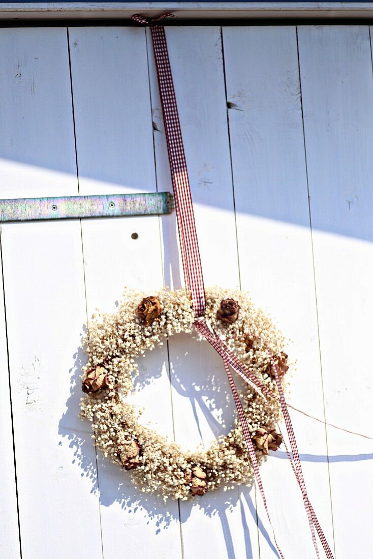 Wreath of gypsophila and dried roses on farm door