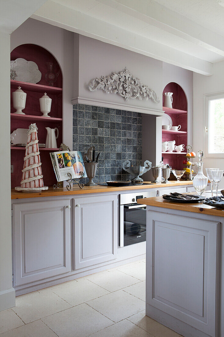 Country-house-style kitchen with fitted shelves in pastel arched niches